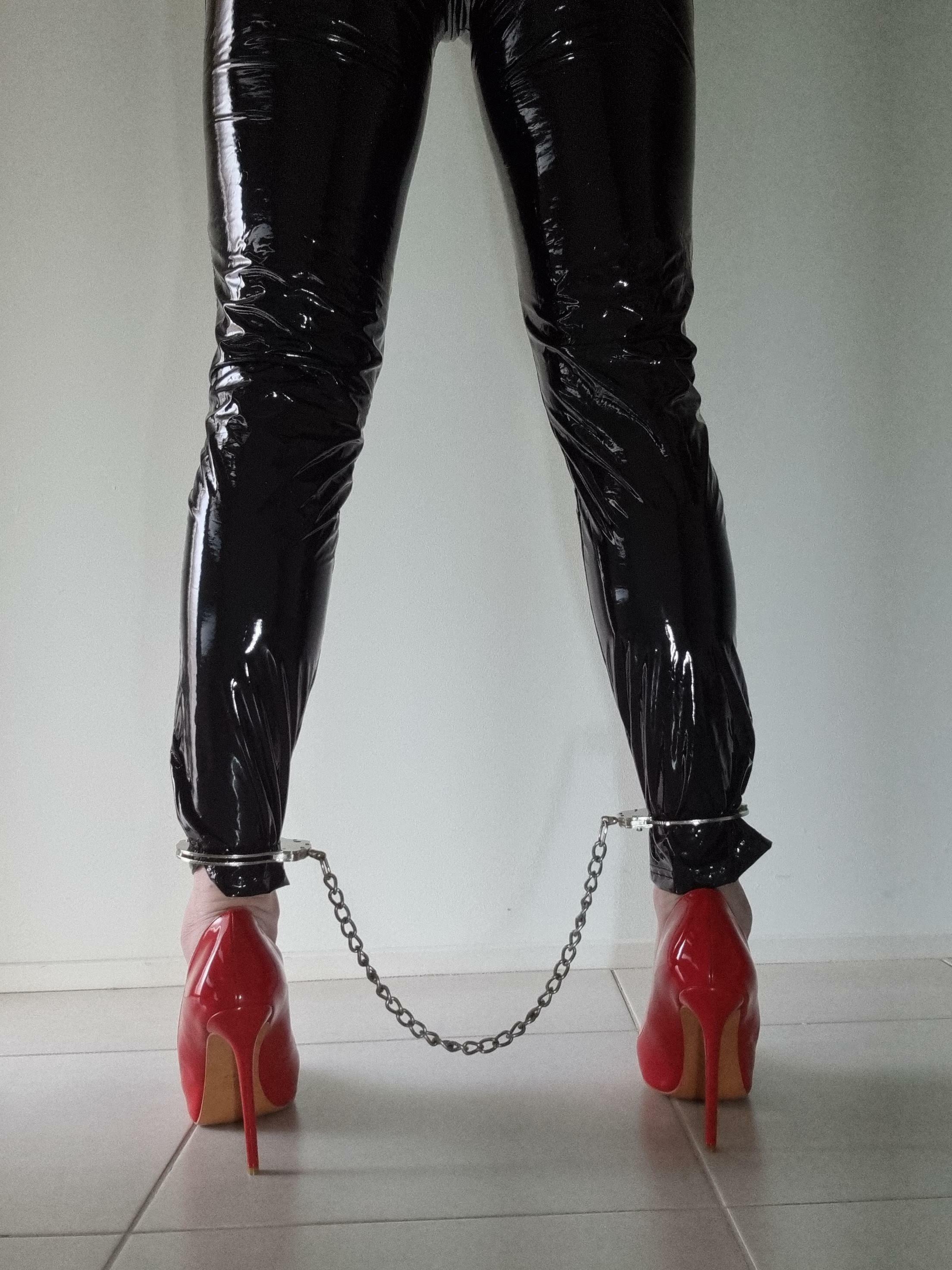 Cuffed in Red Stilettos and Shiny Catsuit