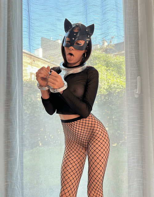 Ahegao face in an iron fiddle, fishnets, sheer top, and a cat mask